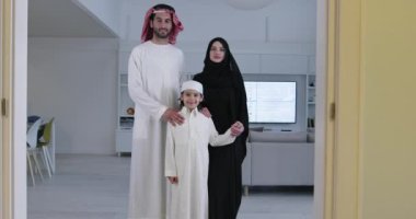 Geleneksel giysiler içinde oğlu olan mutlu Arap aile fertlerinin portresi Ramazan ayı boyunca evde birlikte vakit geçiriyorlar.