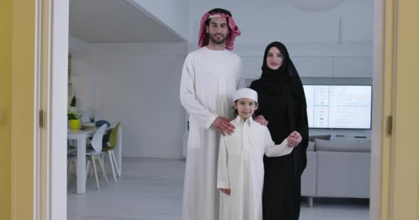 ラマダーン月に家で一緒に過ごす伝統的な服を着た息子を持つ若い幸せなアラビア人ムスリム家族のカップルの肖像画 — ストック動画