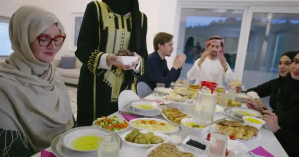 イード ムバラク イスラム教徒の家族は ラマダーン月の自宅で伝統的な食べ物を食べながら携帯電話で写真を撮るIftarディナーを持っています イスラム教のハラル食と飲酒 イスラーム家族 — ストック動画