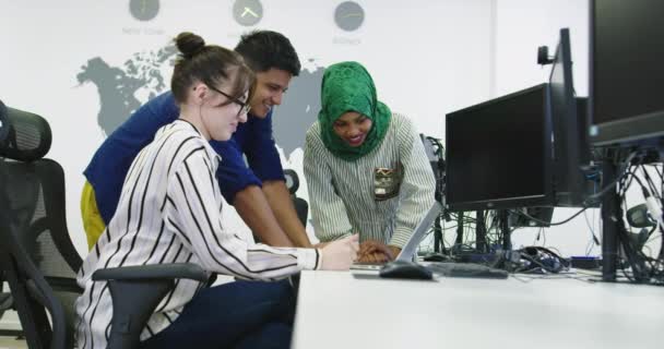 Группа молодых коллег по этническому признаку, одетых в повседневную одежду, сосредоточилась на компьютерном мониторе в офисе стартапа — стоковое видео