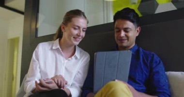 Toplantıda tablet bilgisayar kullanan iki kişi ile Stratup Şirketi