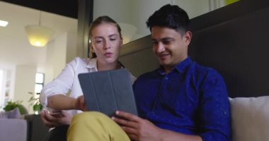 Toplantıda tablet bilgisayar kullanan iki kişi ile Stratup Şirketi