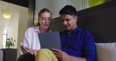 Toplantıda tablet bilgisayar kullanan iki kişi ile Stratup Şirketi