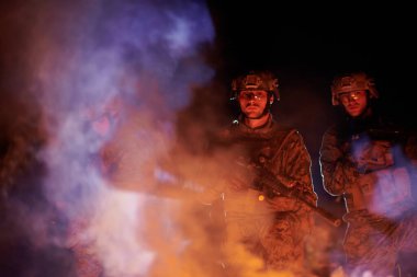 Özel deniz kuvvetleri mangası askerleri arka planda tam bir yangın sonrası grup portresi çektiler.