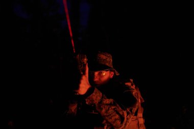 Askerler gece görevinde lazer ışını ışını kullanarak hareket halindeler. Askeri ekip kavramı.