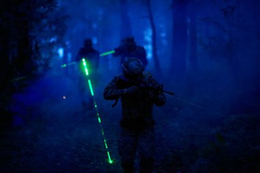 Askerler gece görevinde lazer ışını ışını kullanarak hareket halindeler. Askeri ekip kavramı.