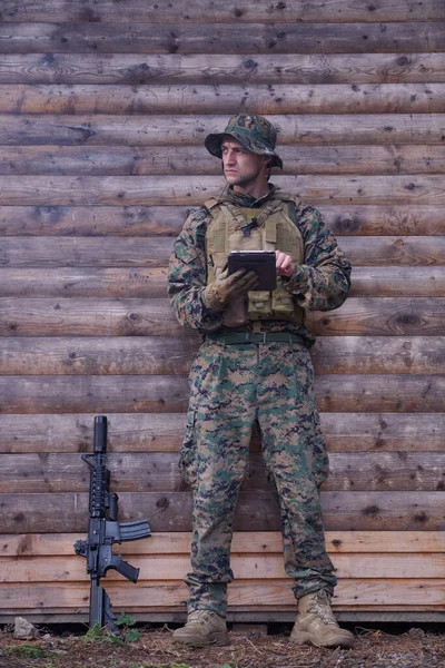 Soldat Mit Tablet Computer Gegen Alte Holzwand Militärlager Mit Freunden — Stockfoto