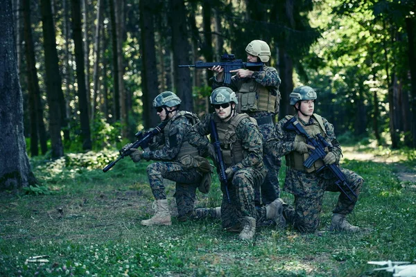 Soldier fighters standing together with guns. Group portrait of US army elite members, private military company servicemen, anti terrorist squad