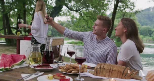 Щасливі друзі тости червоне винне скло під час французької вечері — стокове відео