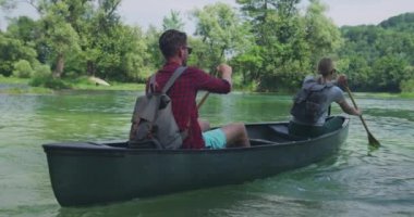 Genç mutlu çift yüzer kano güzel yaz güneşli bir günde nehir veya gölde 