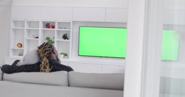 Kanepede oturup birlikte televizyon izleyen Afrikalı çift.