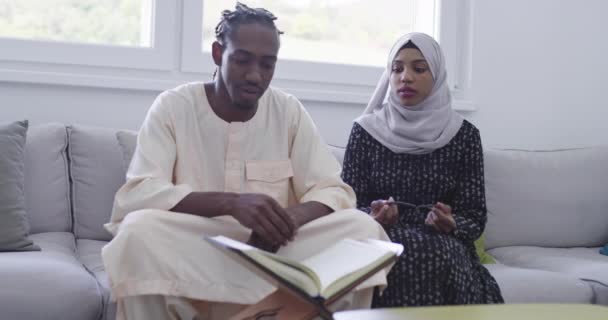 Африканская пара дома читает куран — стоковое видео
