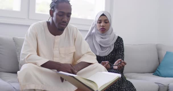 African couple at home reading quran — Stock Video