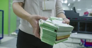 Banka çalışanları banka kasasında kağıt banknotları sıralarken ve sayarken para sayma makinesi kullanıyor. 
