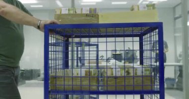 Tıbbi maskeli bir adam dükkanda çanta taşıyor..