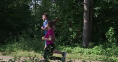 Güzel güneşli ormanda kır yolunda koşan bir çift.