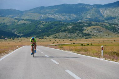 Curvy Country Road 'da spor yaparken profesyonel yarış bisikleti süren triatlon sporcusu.