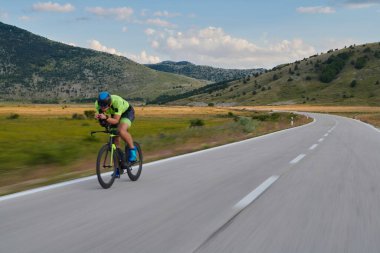Curvy Country Road 'da spor yaparken profesyonel yarış bisikleti süren triatlon sporcusu.