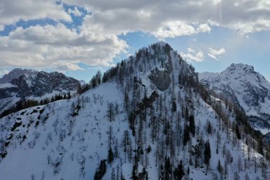 Kışın dağların tepelerinde kar yağıyordu. 