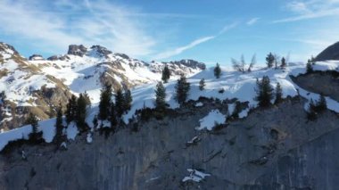 Kışın dağların tepelerinde kar yağıyordu. 