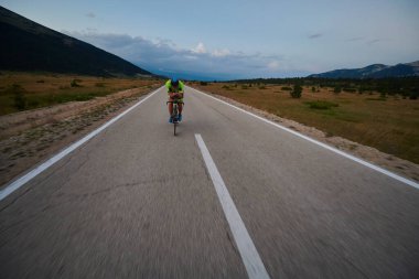 Curvy Country Road 'da spor yaparken profesyonel yarış bisikleti süren triatlon sporcusu.