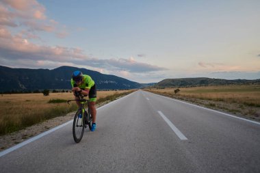 Curvy Country Road 'da spor yaparken profesyonel yarış bisikleti süren triatlon sporcusu.