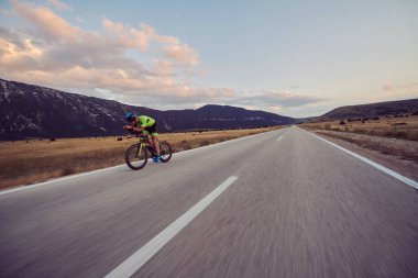 Curvy Country Road 'da spor yaparken profesyonel yarış bisikleti süren triatlon sporcusu.