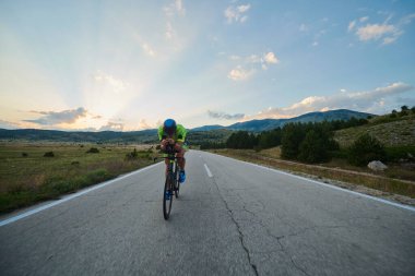 Curvy Country Road 'da spor yaparken profesyonel yarış bisikleti süren triatlon sporcusu.