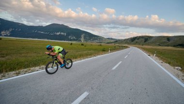 Curvy Country Road 'da spor yaparken profesyonel yarış bisikleti süren triatlon sporcusu.