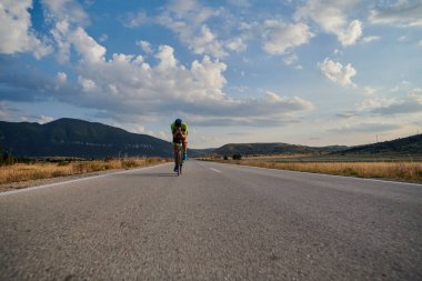 Curvy Country Road 'da spor yaparken profesyonel yarış bisikleti süren triatlon sporcusu.