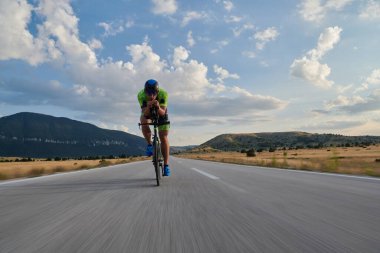 Curvy Country Road 'da spor yaparken profesyonel yarış bisikleti süren triatlon sporcusu.