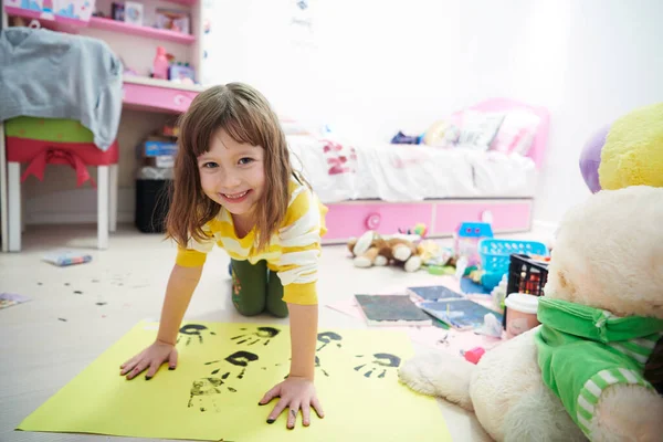 Nettes kleines Mädchen zu Hause beim Malen mit den Händen — Stockfoto