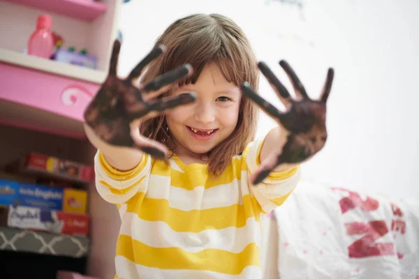 Mignonne petite fille à la maison peinture avec les mains — Photo