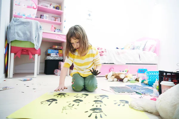 Nettes kleines Mädchen zu Hause beim Malen mit den Händen — Stockfoto