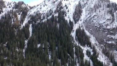 Kışın dağların tepelerinde kar yağıyordu. 