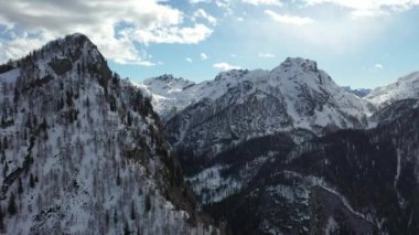 Kışın dağların tepelerinde kar yağıyordu. 