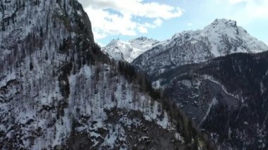 Kışın dağların tepelerinde kar yağıyordu. 