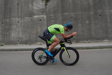 Sabah antrenmanında bisiklet süren triatlon sporcusu.