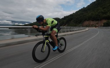 Sabah antrenmanında bisiklet süren triatlon sporcusu.