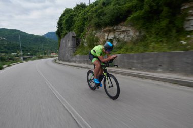 Sabah antrenmanında bisiklet süren triatlon sporcusu.