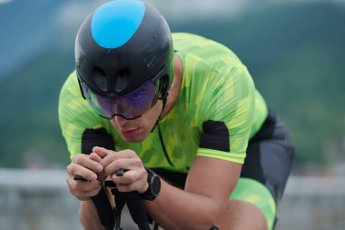 Sabah antrenmanında bisiklet süren triatlon sporcusu.