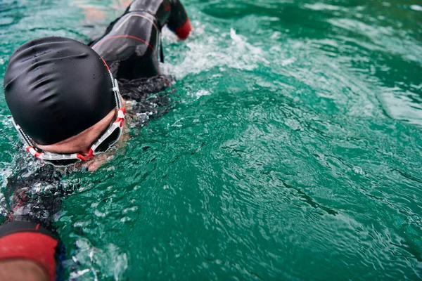 Triatlon atléta úszás a tavon búvárruhában — Stock Fotó