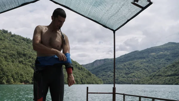 Спортсмен тріатлону готується до тренувань з плавання на озері — стокове фото