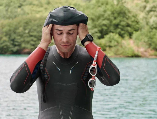 Atleta triatlo se preparando para o treinamento de natação no lago — Fotografia de Stock