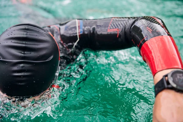 Triatlon atleet zwemmen op meer dragen wetsuit — Stockfoto