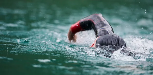 Triatlon atléta úszás a tavon búvárruhában — Stock Fotó