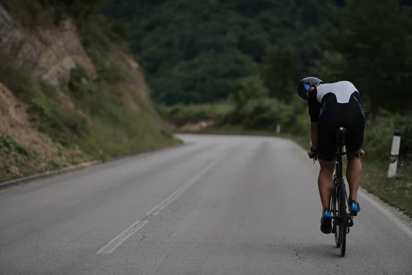 Triathlon idrottare rida en cykel klädd i svart — Stockfoto