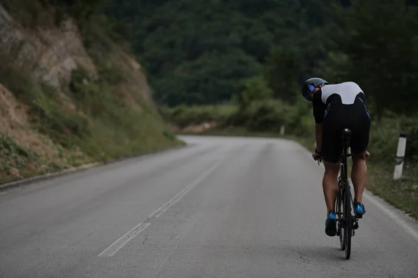 Triathlon athlete riding a bike wearing black — Stock Photo, Image