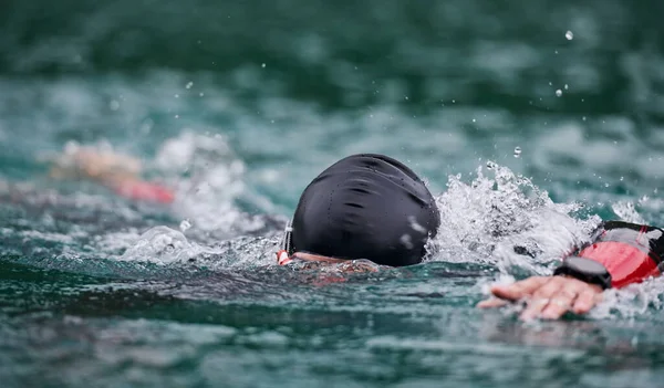 Triathlon athlete swimming on lake wearing wetsuit — Stock Photo, Image