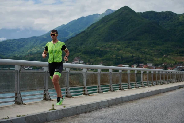 Triatlon atlet běží na ulici — Stock fotografie